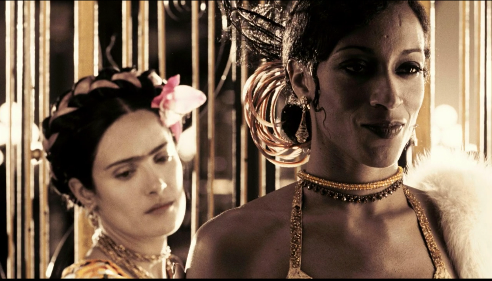 Frida de pie detr&aacute;s de Josephine Baker mir&aacute;ndola, Josephine sonr&iacute;e.