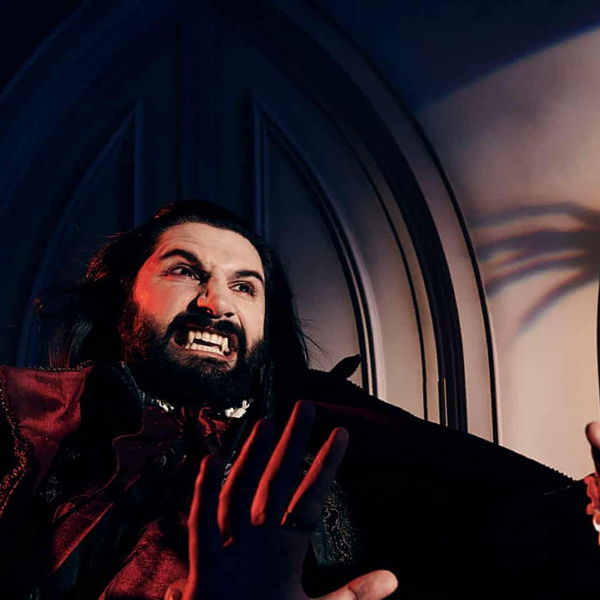 Laszlo showing his fangs and looking at someone off camera menacingly.