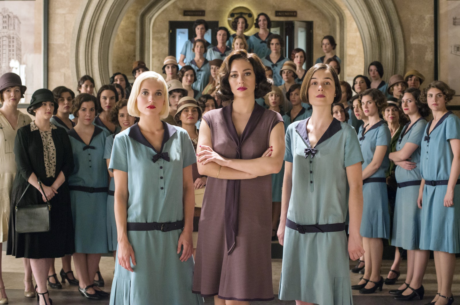 Todo el elenco de chicas de cable, todas vistiendo su uniforme y de pie cerca para una foto.