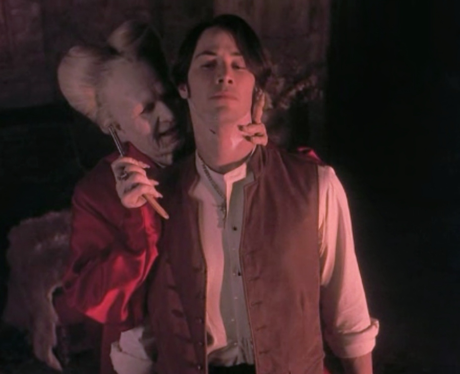 Drácula sostiene a un preocupado Jonathan por el cuello mientras sostiene una navaja en la otra mano y lo afeita.