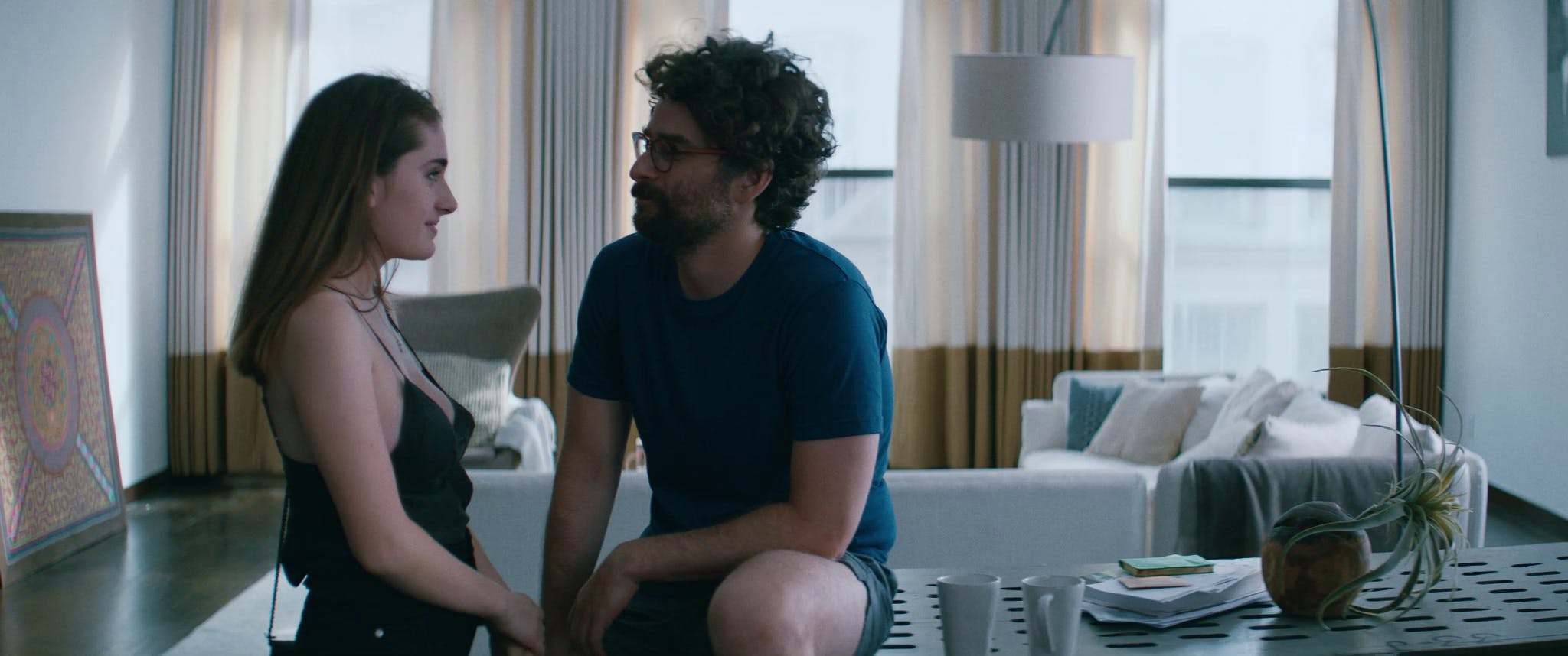 Danielle smiling at Max while both are talking. They are at his house.