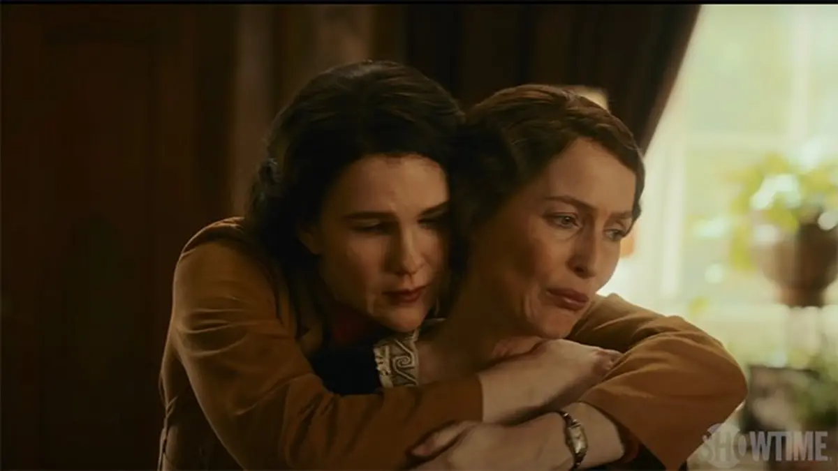 Lorena standing behind Eleanor hugging her from behind.