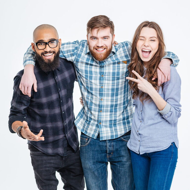 A group of 3 attractive friends smile and are locked arm and arm.