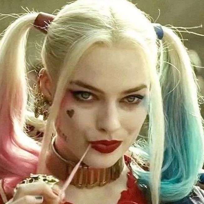 Harley Quin wearing her hair in 2 pontails, with ah heart tattoo on her cheek glaring ahead