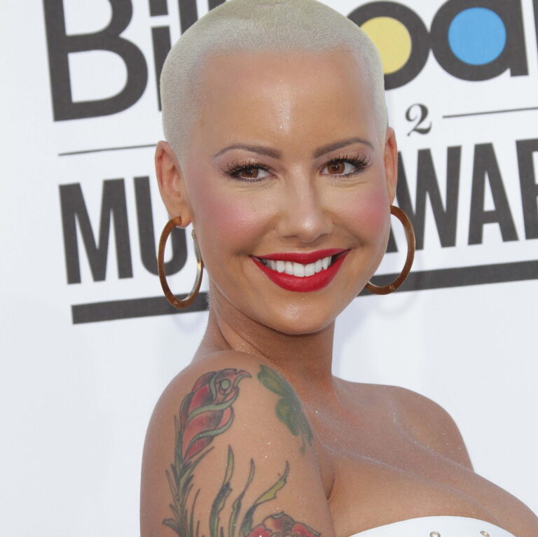 Amber Rose at a carpet event wearing a dress and smiling.