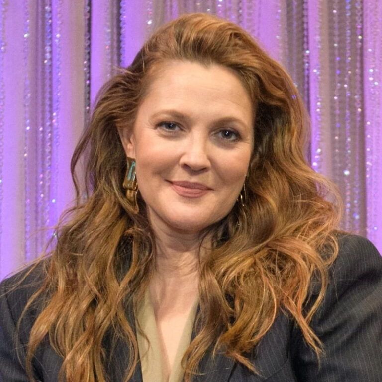 Drew Barrymore smiling wearing a blazer during a her talkshow.
