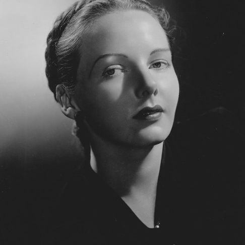 Black and white image of M.F.K Fisher as a young woman, with a soft lighint and looking to her side at the camera.