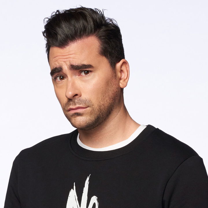 David Rose with his eyebrows raised looking at the camera with a white background.