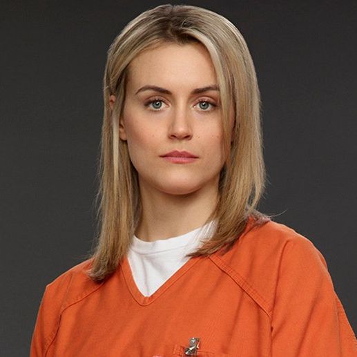 Piper with a orange prison uniform with a serious look.