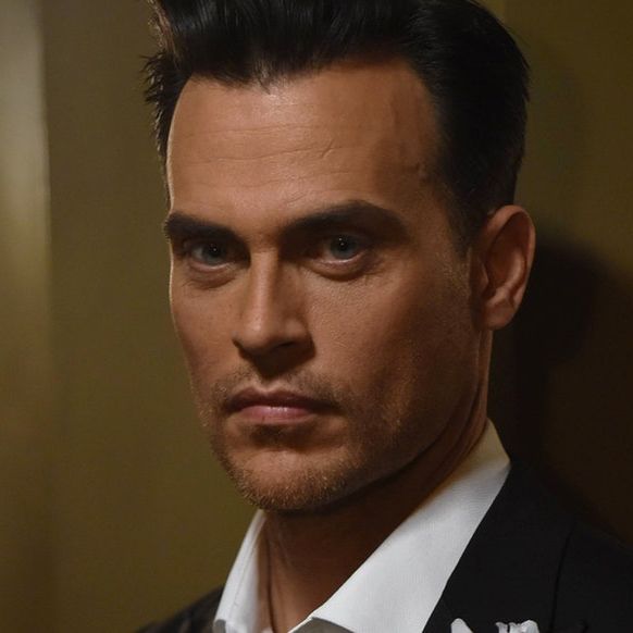 Will Drake wearing a suit, with a serious expression looking at someone out of frame.