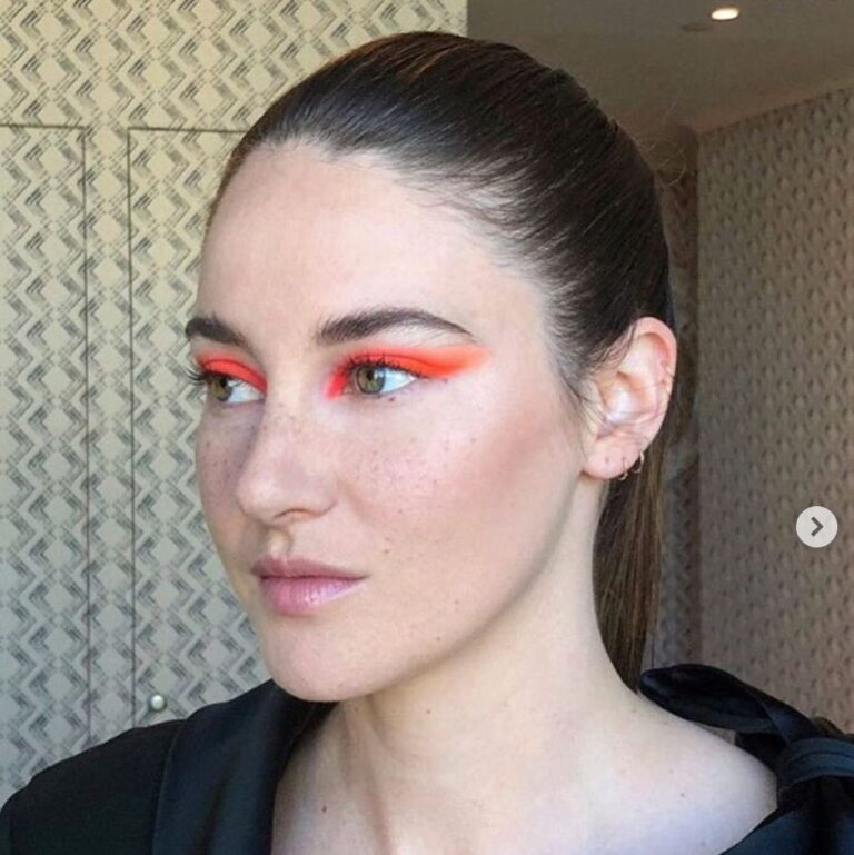 Portrait of Shailene Woodley smiling to the camera wearing natural makeup.
