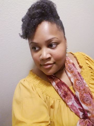 Tiffany con bufanda y blusa, sonriendo mientras mira a su lado.