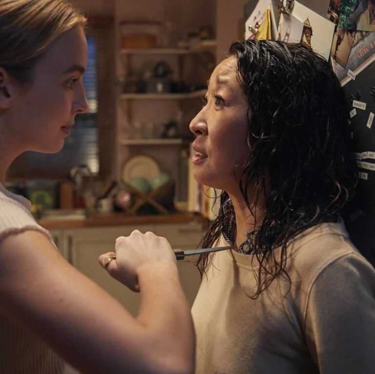 Villanelle confronting Eve inside her home holding a knife to her neck.