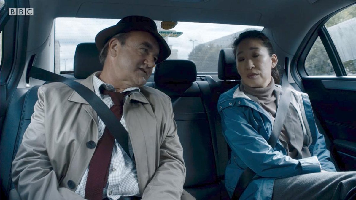 Eve and Bill in the back of a car talking about a case.