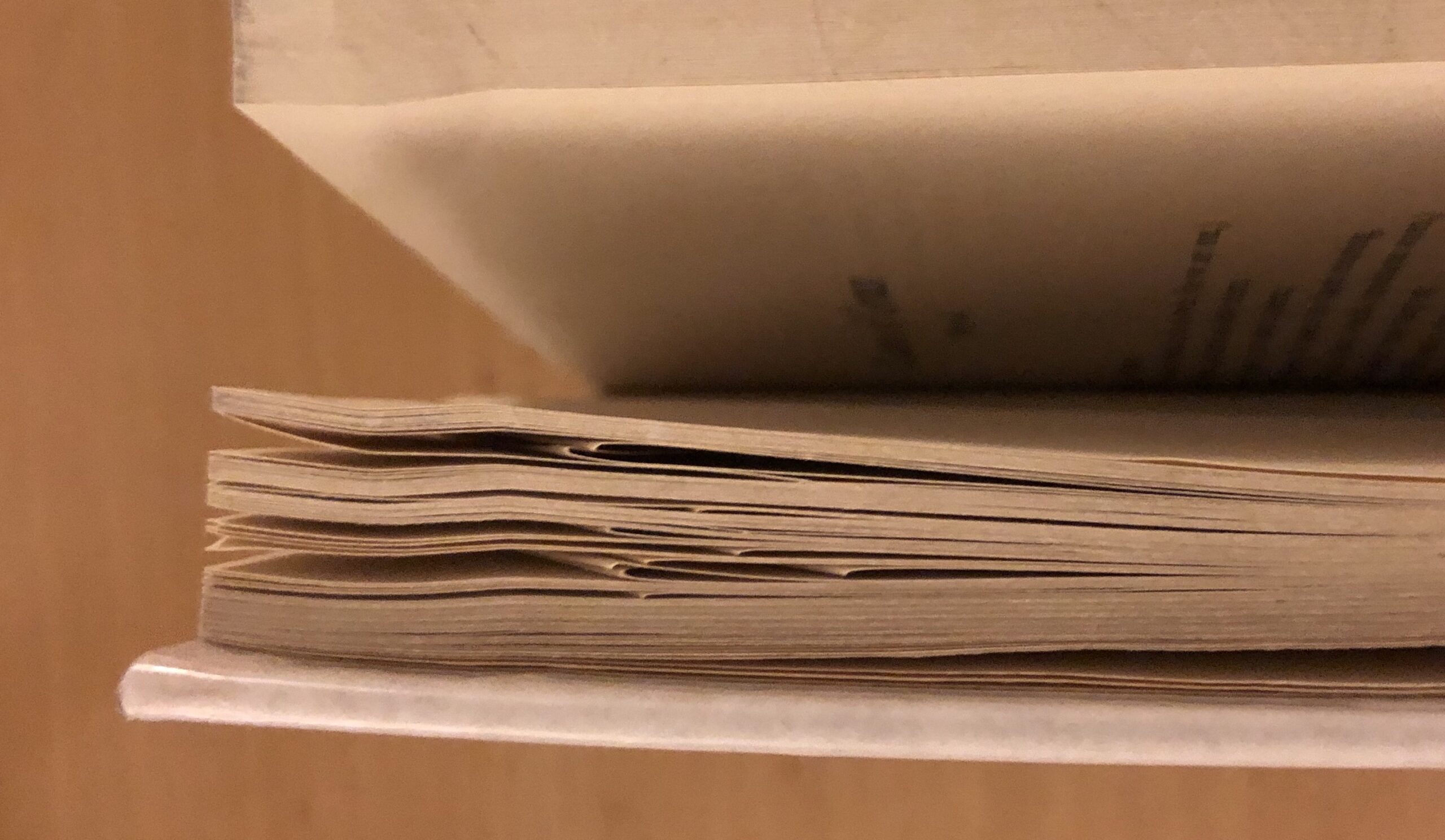 A close up of a book on its side. The first couple pages are spread open.