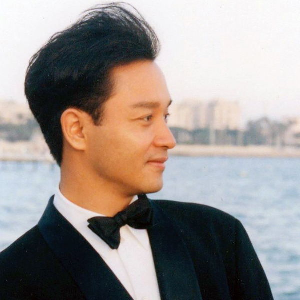 Leslie Cheung in a tuxedo looking to his side.