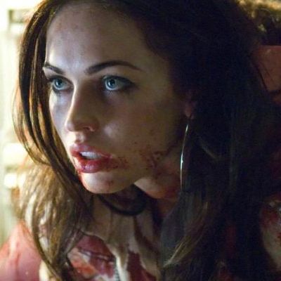 Jennifer leaning forward with a serious look and her face with blood.