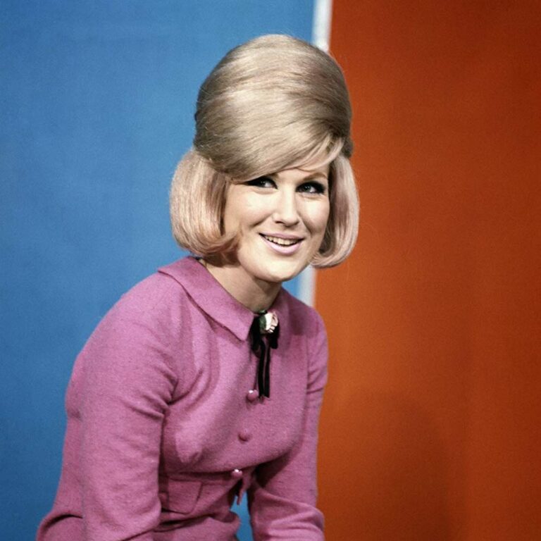 Dusty Springfield, posing for a portrait smiling and her hair in an up do.