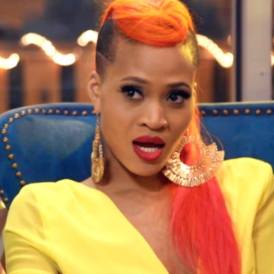 A scene from a music video with Margeaux posing sitting on an armchair.