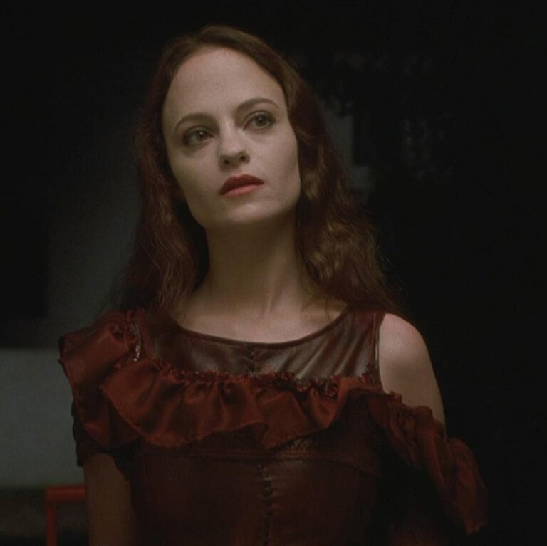 May standing confidently next to a door looking at someone off camera.