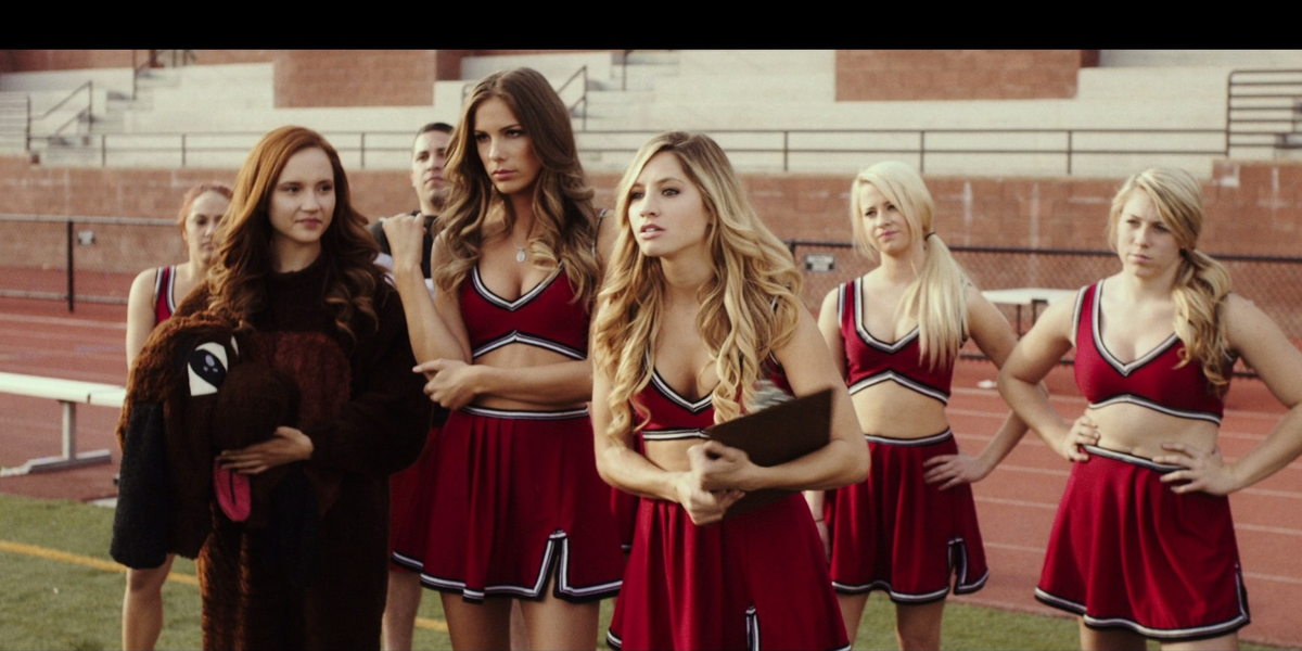 The cheerleaders confronting someone off camera all with their hands on their waists and annoyed expressions.