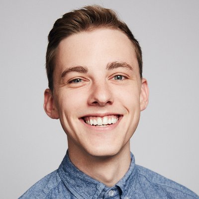 Portrait of Jon Cozart grinning against a plain background.
