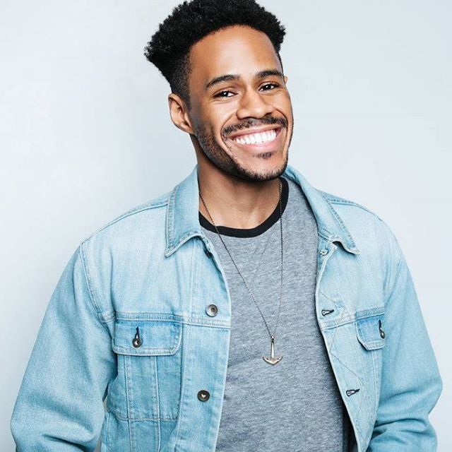 Jay Jurden wearing a denim jacket and grinning.