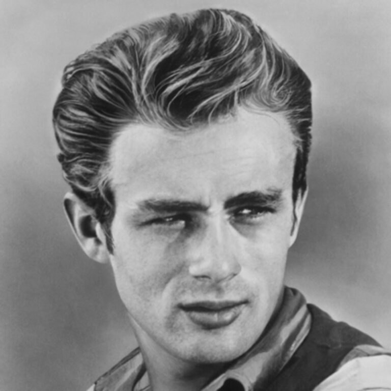 Black and white image of James Dean smirking and looking to the side.