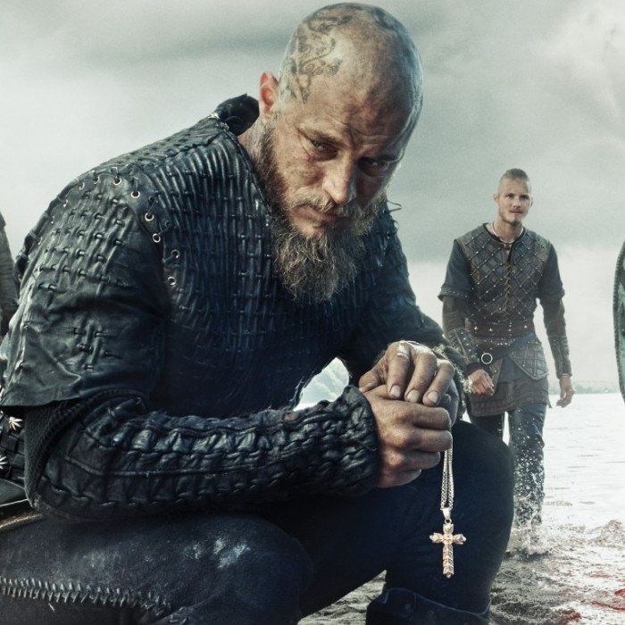 Cover of the Vikings show featuring Ragnar kneeling with a cross necklace in hand.