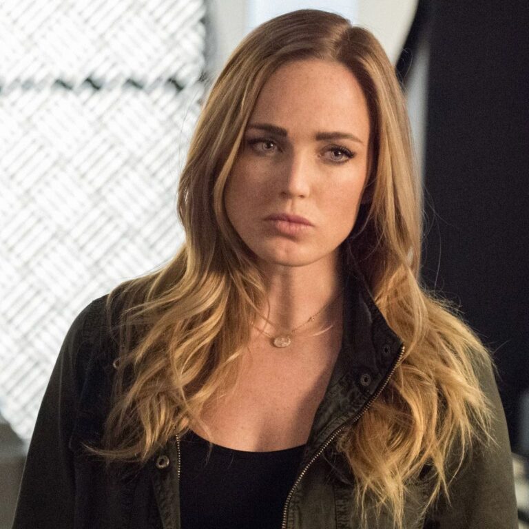Sara Lance in casual clothing looking at someone with a serious expression.