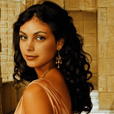 Inara looking to her side smiling.