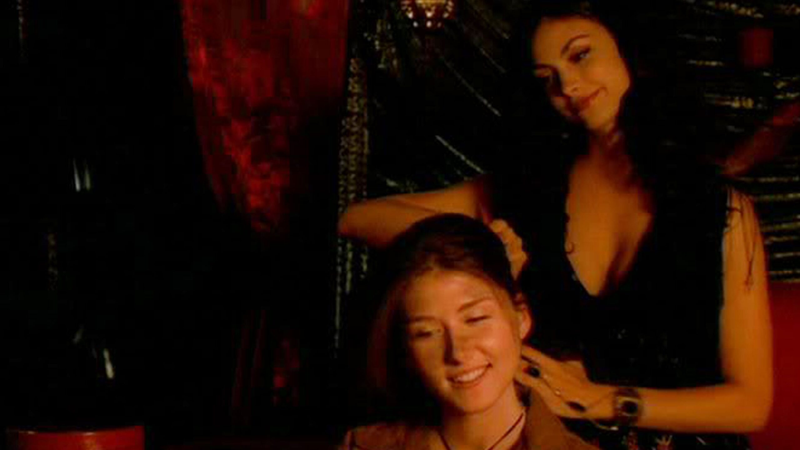 Inara consolando a otra mujer cepill&aacute;ndose el cabello mientras sonr&iacute;e.