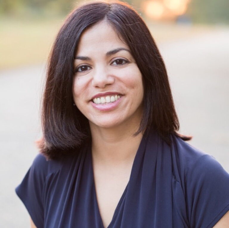 Portrait of Daisy Hernandez smiling.