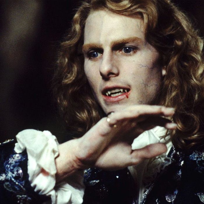 Lestat with blood near his mouth after feeding holding his arm in front of him with an angry expression.