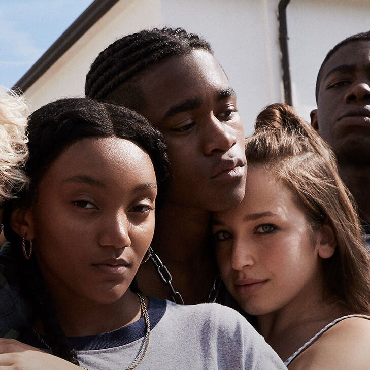 Caitlin at the center looking at the camera while her class mates surround her very closely.