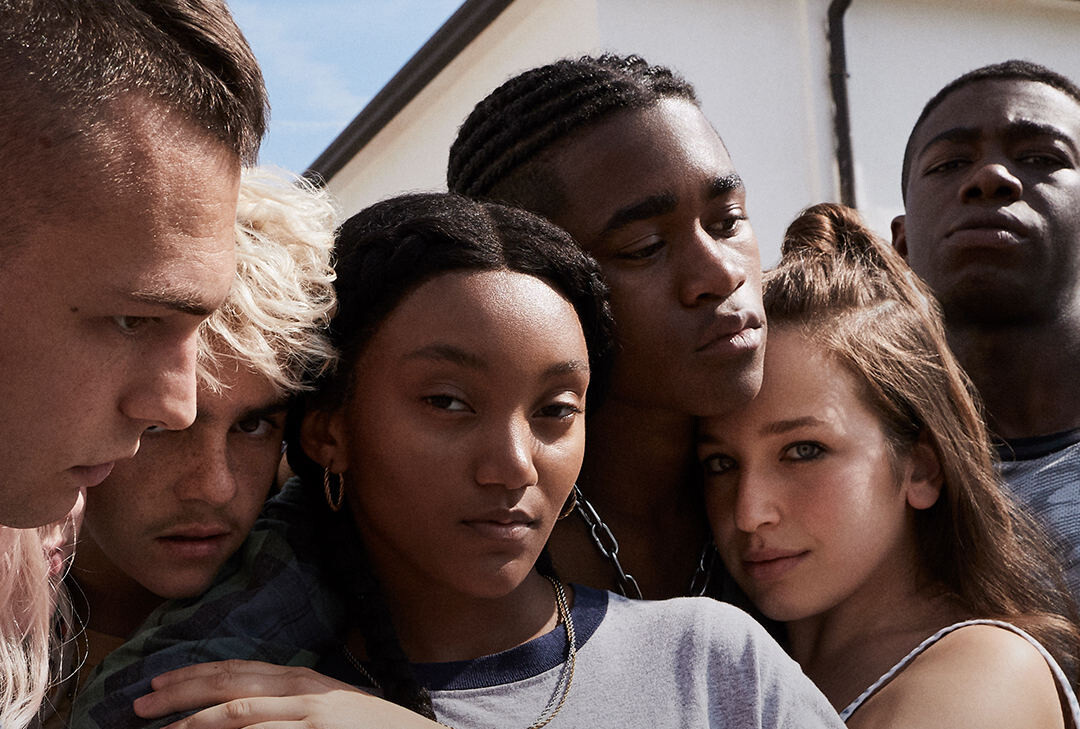Caitlin at the center looking at the camera while her class mates surround her very closely.