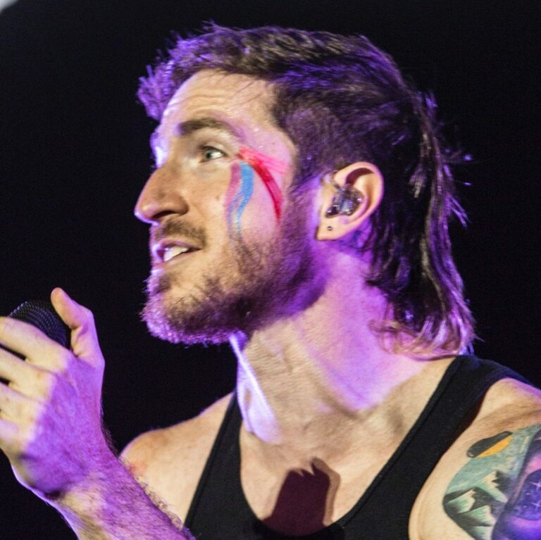 Nicholas performig onstage wearing a wife beater and face painting.