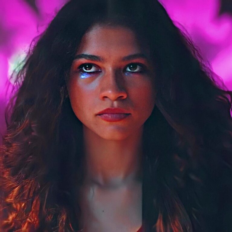 Closeup of Rue looking at someone out of frame with glitter under her eyes.