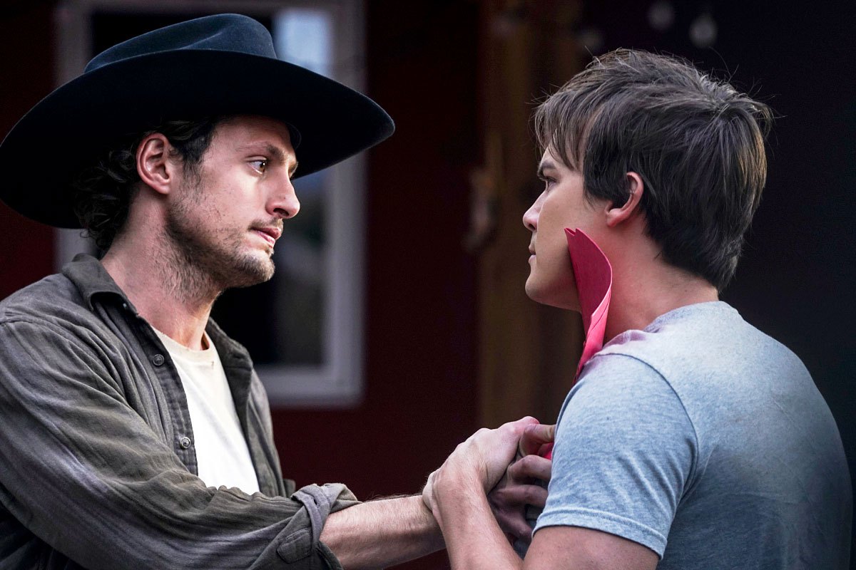 Michael and Alex having an emotional moment facing each other. Alex is holding Michael's hand against his heart.