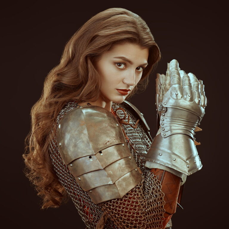 Image of a Beautiful medieval woman warrior in chain mail and plate armor on a black background.