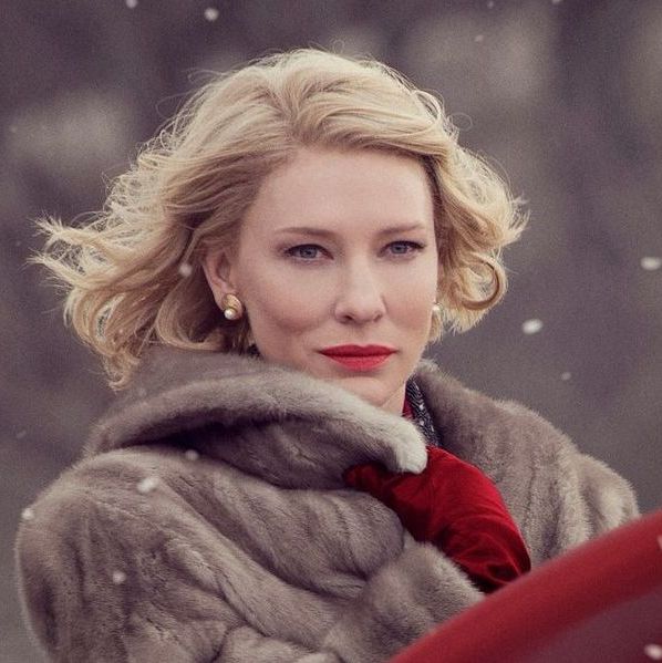 Carol wearing a winter coat and red lipstick looking confidently ahead.