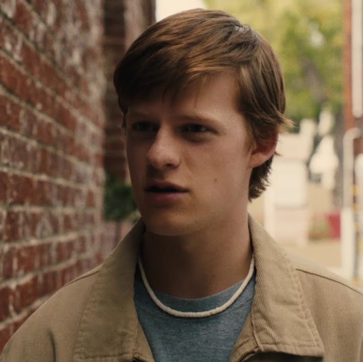 Danny in a narrow street, looking annoyed at someone off camera.