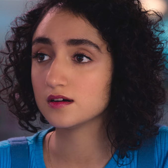 Muskaan looking at someone off camera with a surprised expresion.