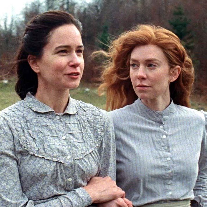 Abigail and Tallie walking arm in arm. Tallie is looking intently at Abigail while she talks.