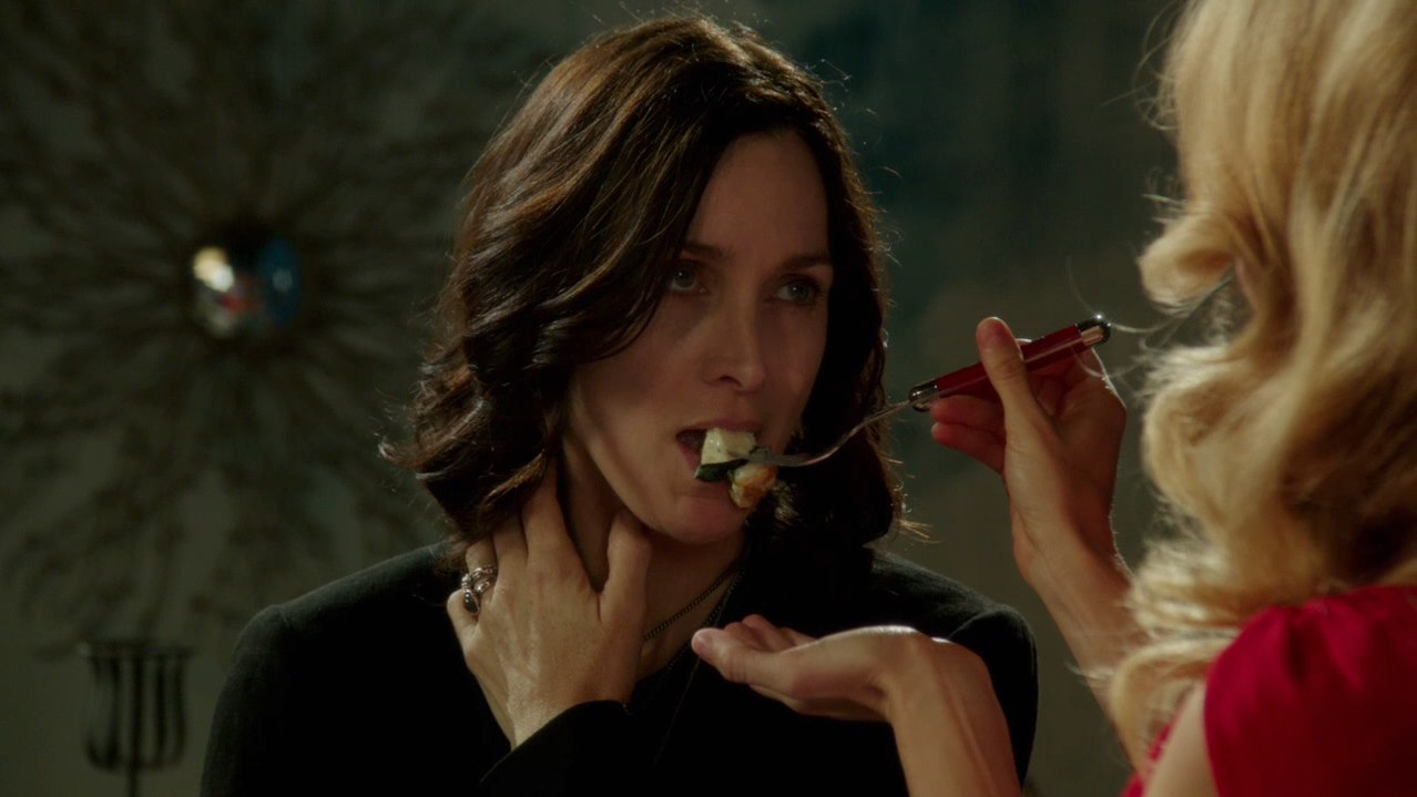 Amy feeding Saffron with a fork, while Saffron looks at Amy with a serious look.