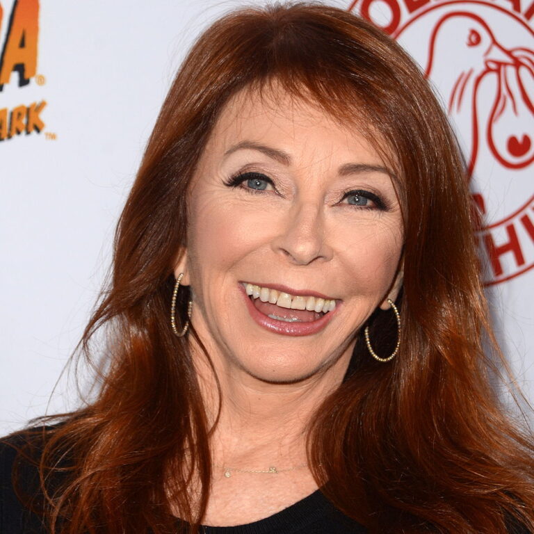Cassandra Peterson with her hair down smiling bit at a carpet event.