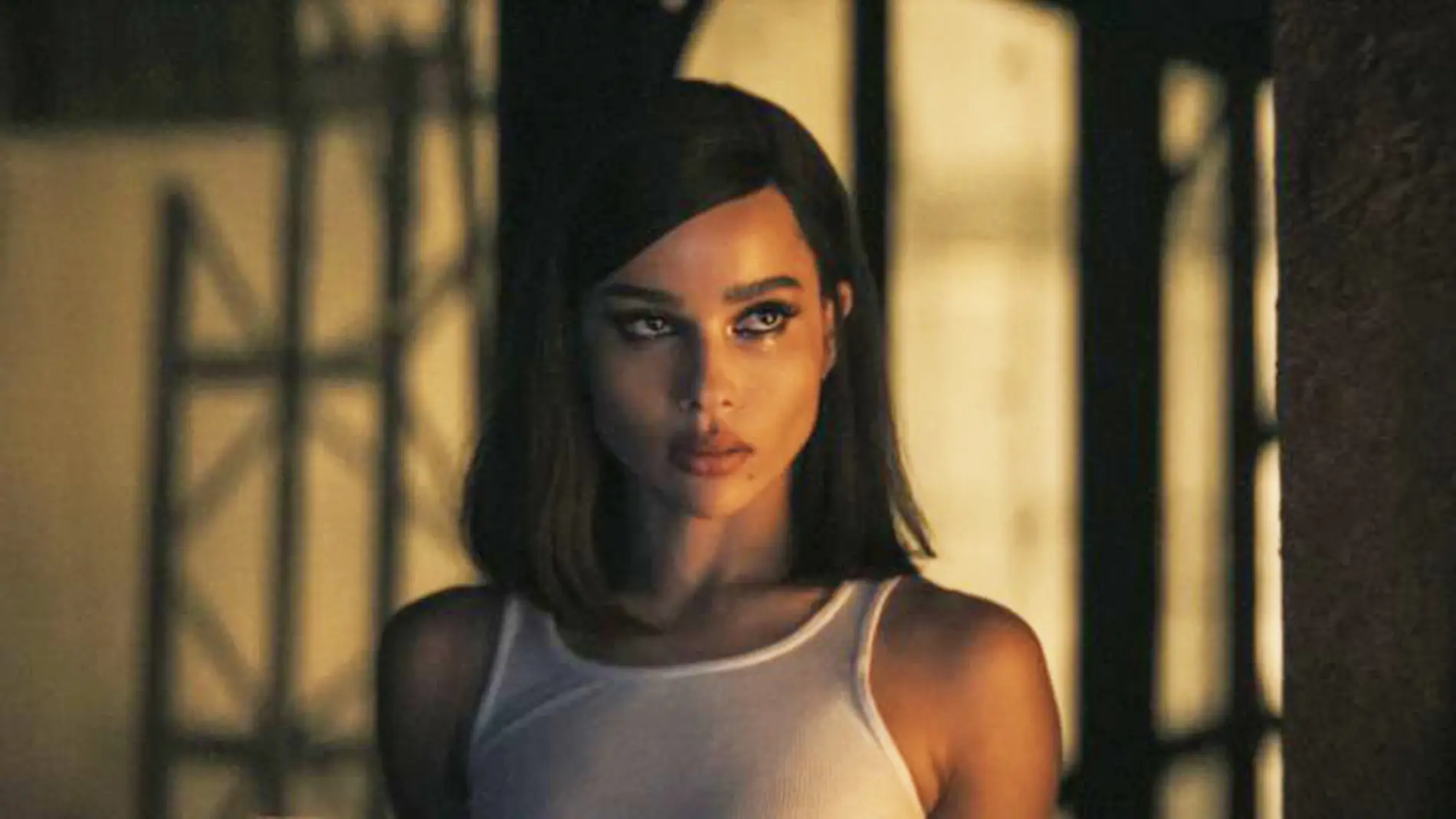 Selina Kyle wearing a tanktop, with her eyes watery looking at Batman with a serious expression.