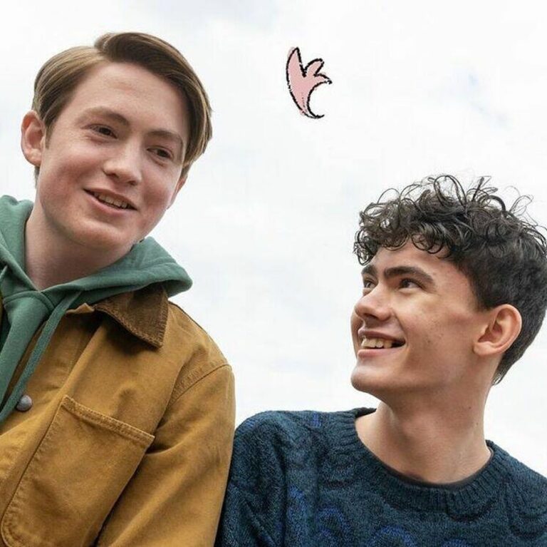 Charlie and Nick standing together smiling and laughing. There are leaves drawn into the scene.