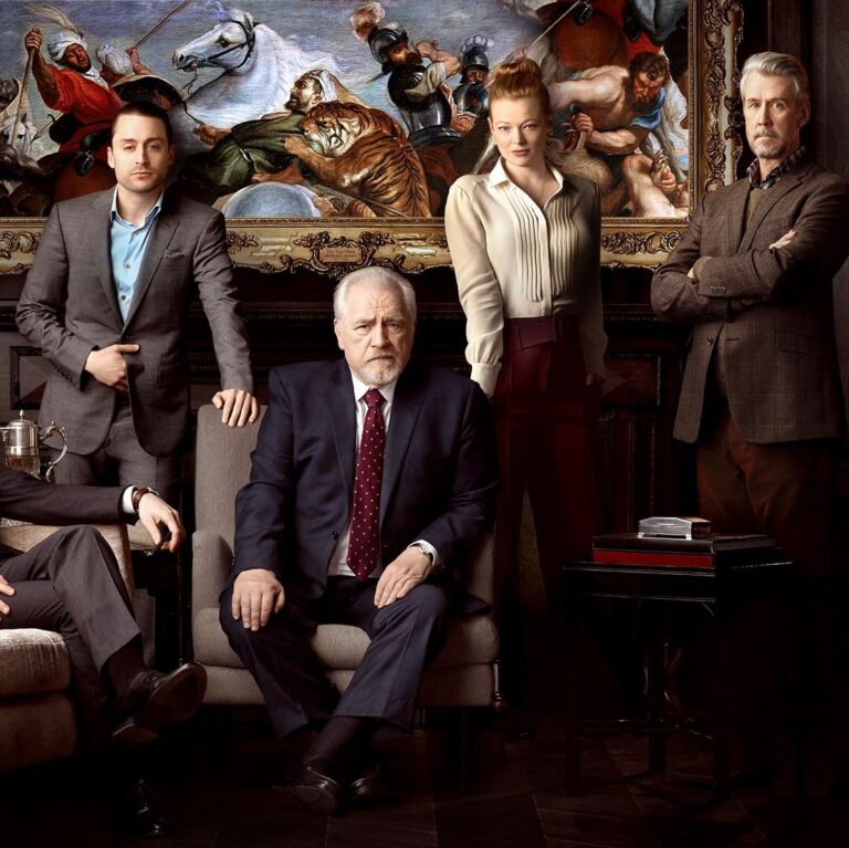 The Roys, posing in front of a large painting.