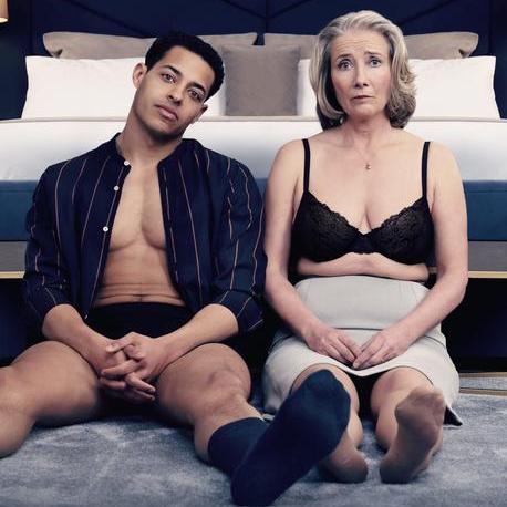 Nancy and Leo sitting on the edge of the bed half dressed. Nancy has a worried expression.